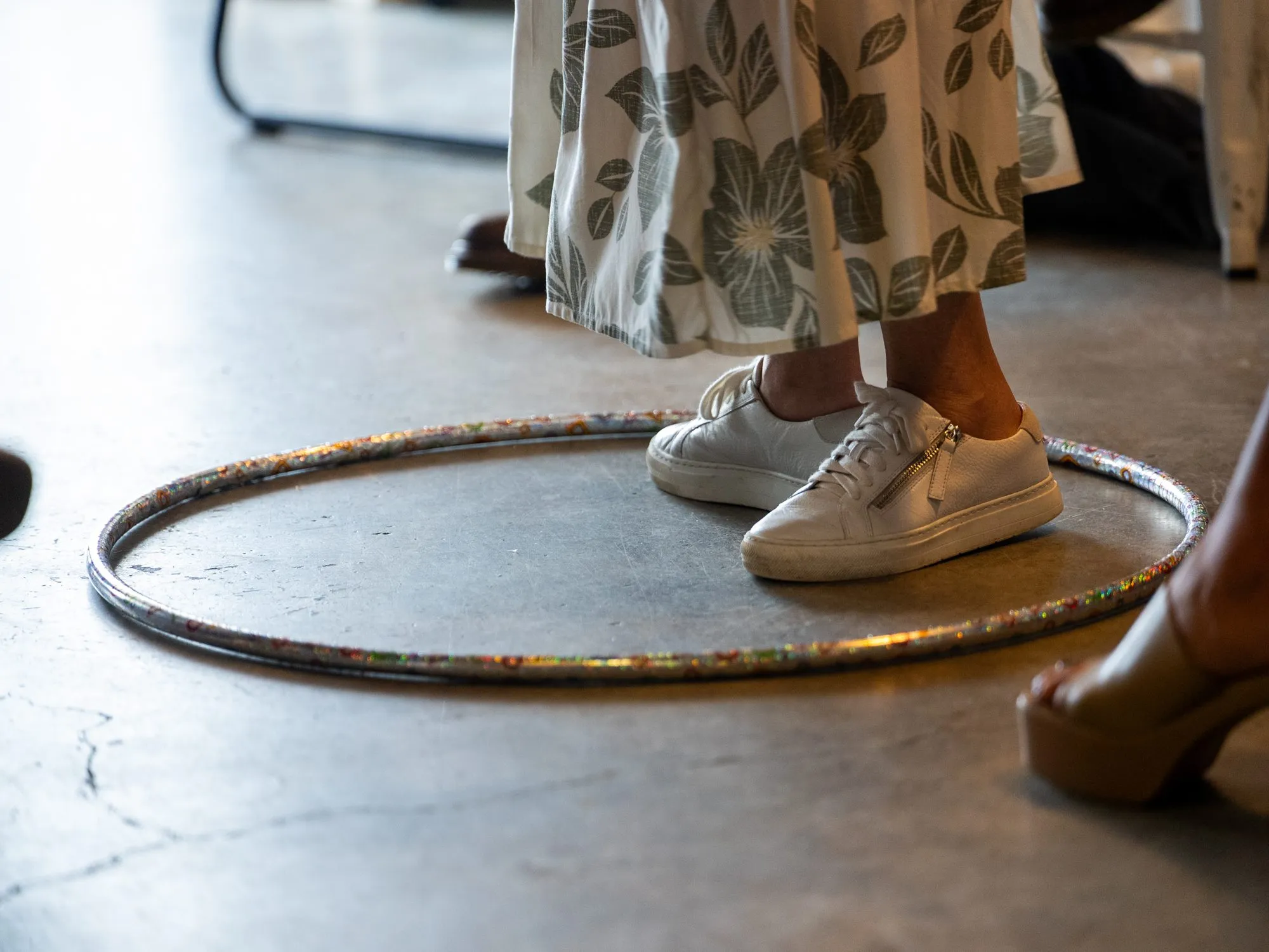 A participant’s feet stepping into a hoop on the floor during a live experience