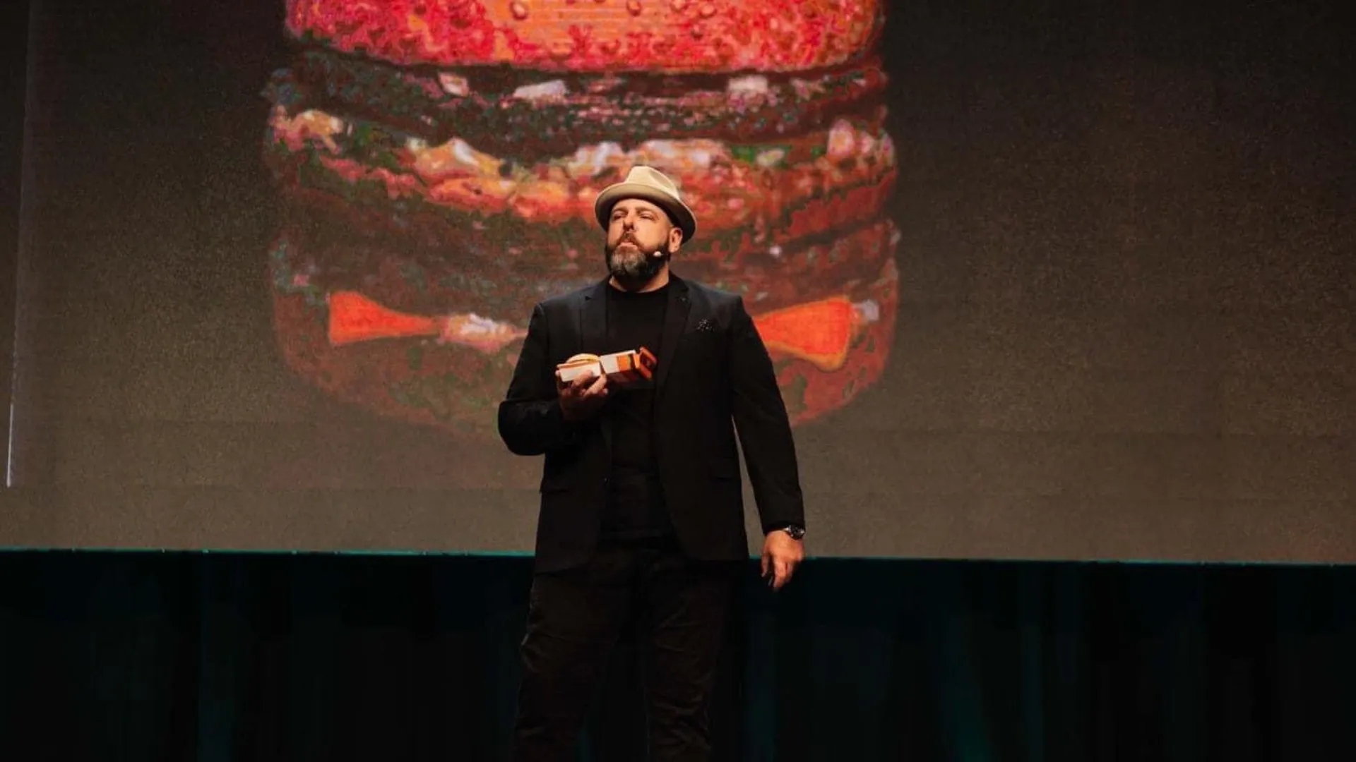 Brett on stage holding up a Big Mac to the audience